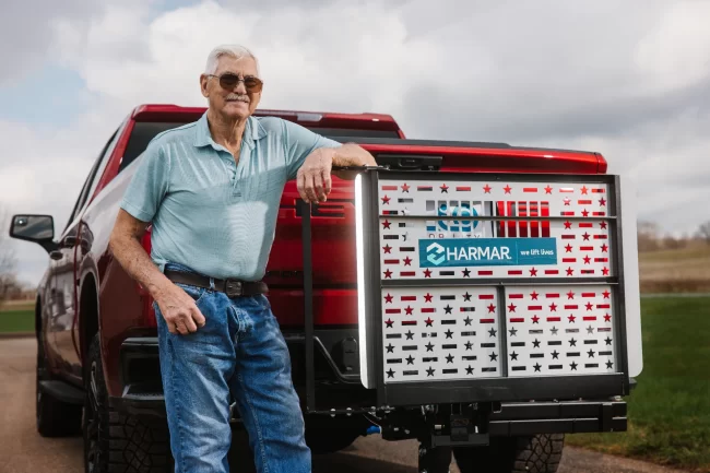 A vehicle lift installed on the back of a man's pickup truck.