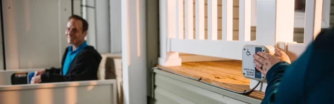 A man uses a vertical platform lift to gain access to his home.