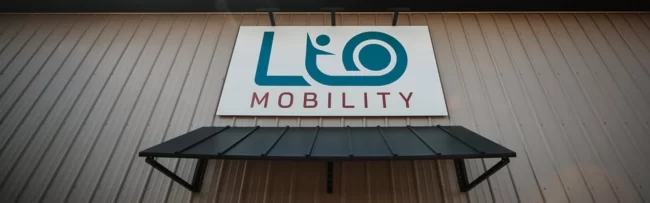 Our Team The LIO Mobility Logo hanging above the main entrance of their building.