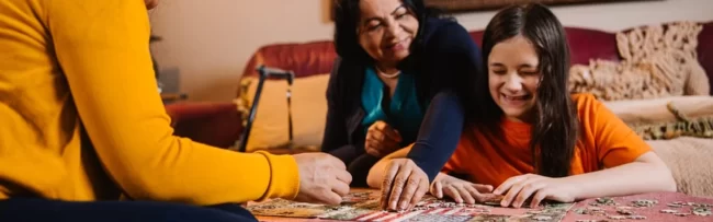 A family working to put together a puzzle.