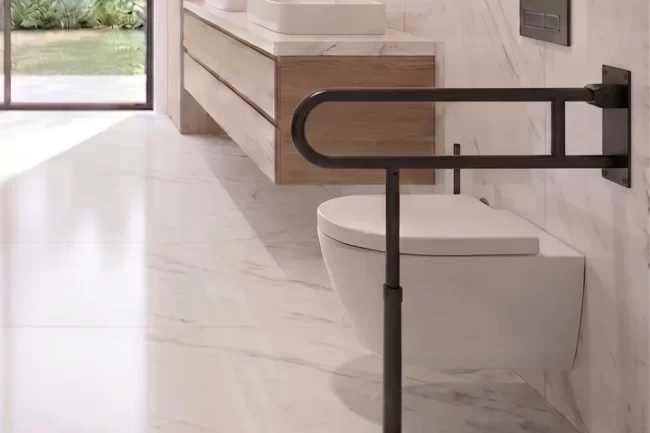 Grab Bars for the Toilet A toilet with a grab bar installed next to it for greater safety and stability.