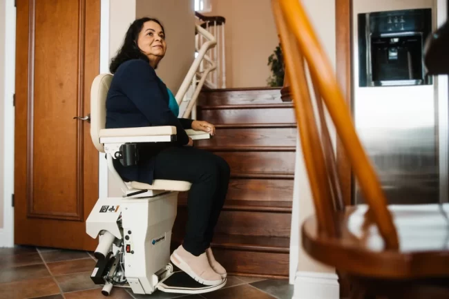 A woman prepares to use the stairlift in her home.