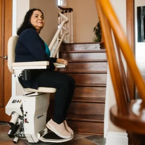 A woman prepares to ascend a staircase in a stairlift.