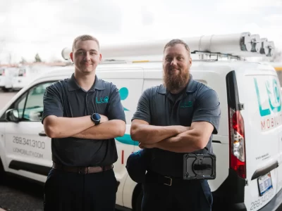 A photo of LIO Mobility employees, Jadon and Rich, standing in front of their service van.