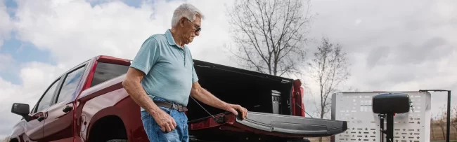 Latest-News-aspect-ratio-1920-600 A man prepares to use the vehicle lift installed on the back of his pickup truck.