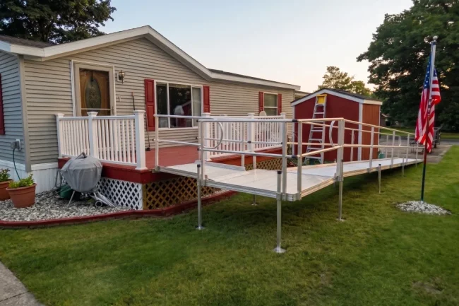 A long, L-shaped wheelchair ramp leading to the back deck of a home.