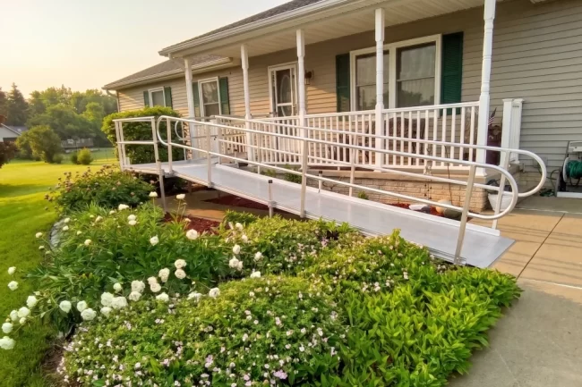 An L-shaped wheelchair ramp that has been installed onto the front porch of a home.