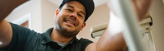 A LIO Mobility service technician repairs a stairlift in a client's home.