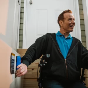 A man pressing a button to activate his vertical platform lift.