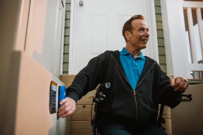 A man pressing a button to activate his vertical platform lift.