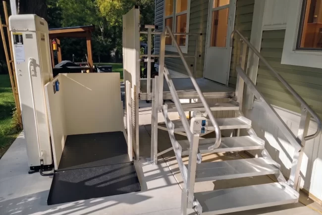 A vertical platform lift installed on the front deck of a client's home.