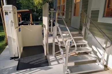 A vertical platform lift installed at a home's front entrance.