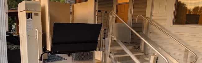A vertical platform lift that has been installed at the front entrance of a home.